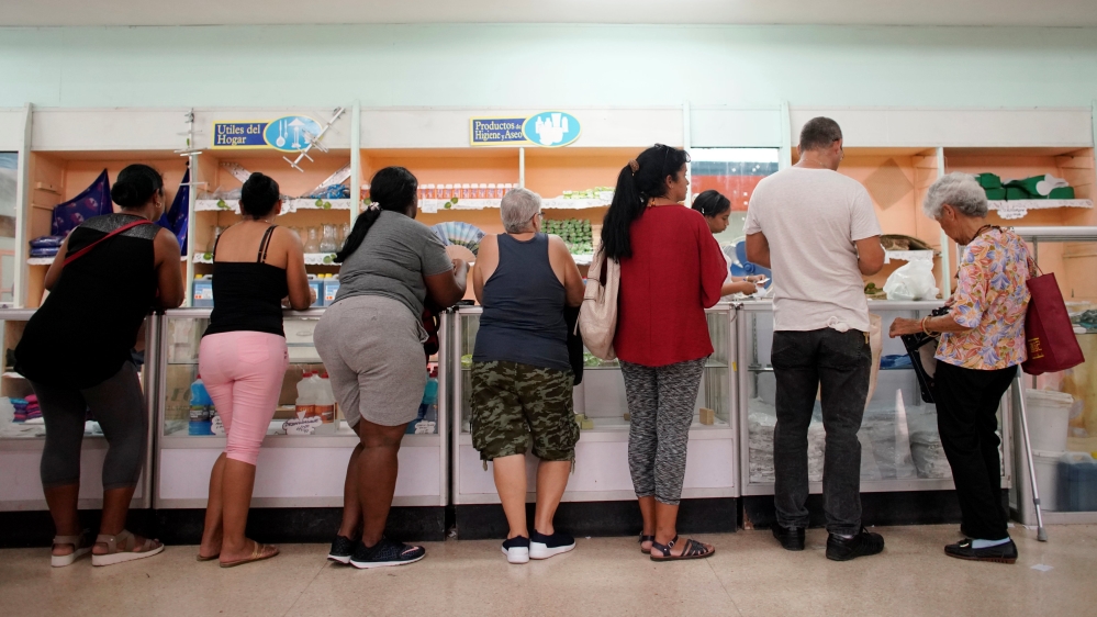 Cubanos esperan a ser atendidos en una tienda.
