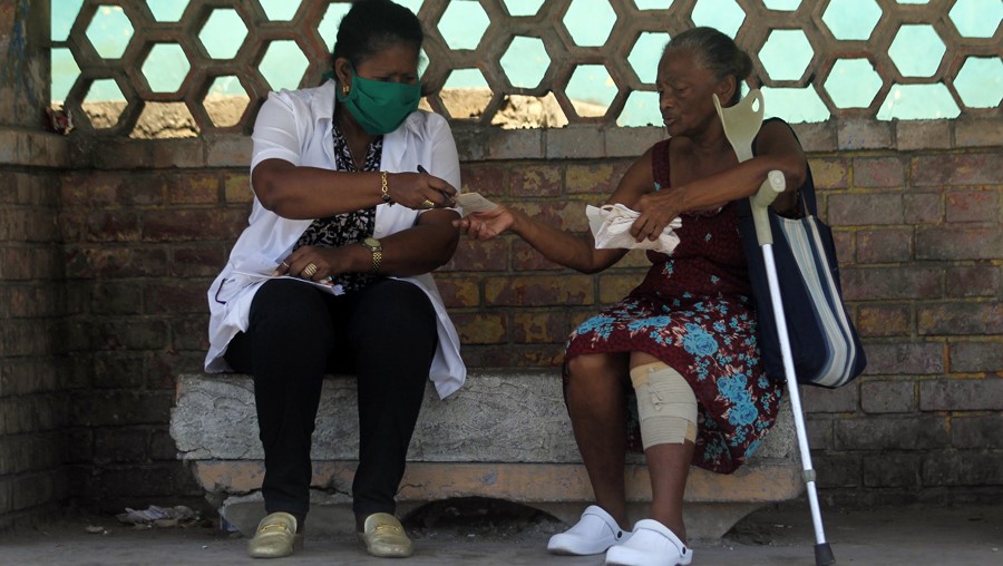 Una doctora entrega una receta a una anciana en Cuba.