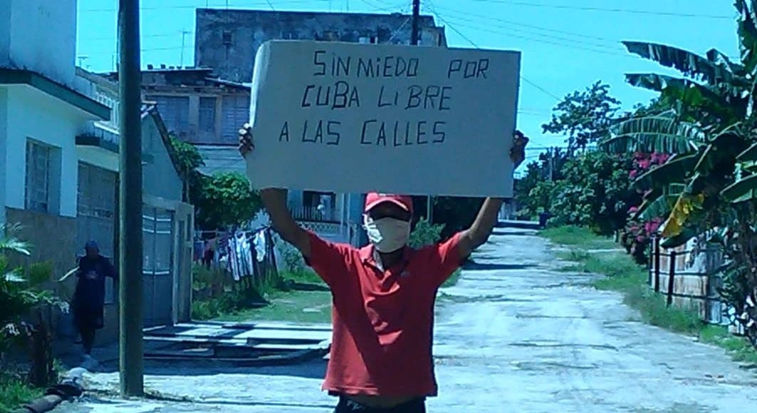Activista de la UNPACU con un cartel de protesta.
