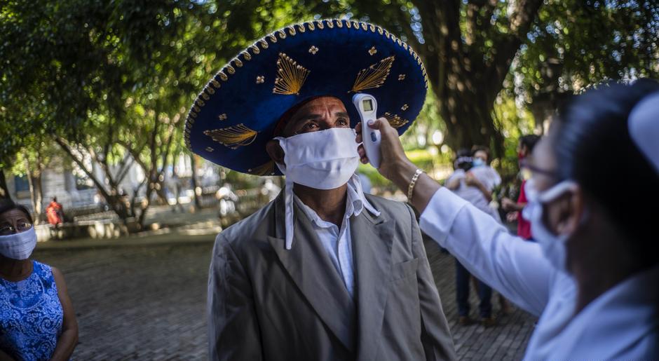 Una doctora le toma la temperatura a un turista en Cuba.