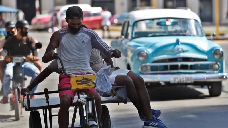 Dos personas van en una bicicleta en La Habana.