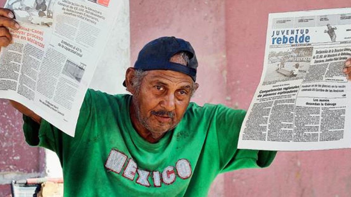 Un cubano sostiene ediciones de Granma y Juventud Rebelde.