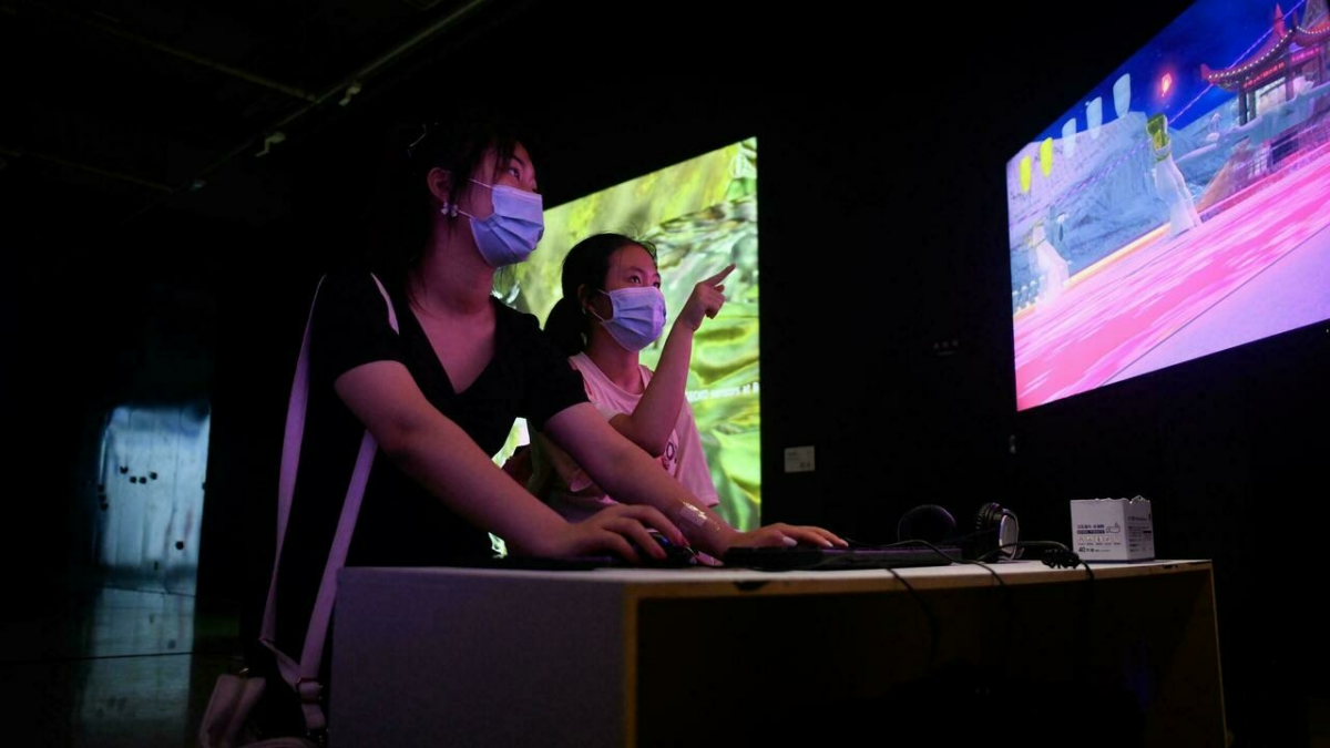 Dos personas juegan en una exposición sobre el arte digital en el museo de Pekín.