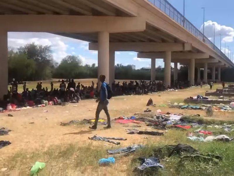 Migrantes acampan bajo el puente que conecta Del Río en Texas con México.