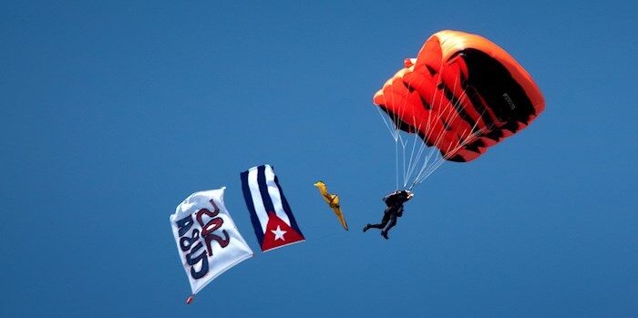 Un miembro del Team Eagle salta con bandera cubana y pancarta sobre el Memorial Cubano de Miami.