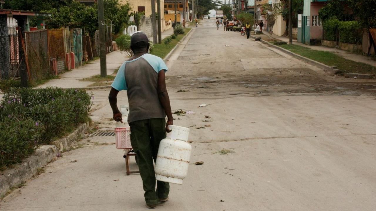 Un hombre carga con balitas de gas en La Habana.