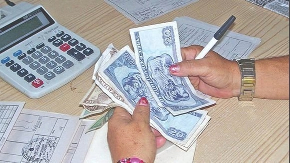 Una trabajadora cuenta dinero en un centro de trabajo.