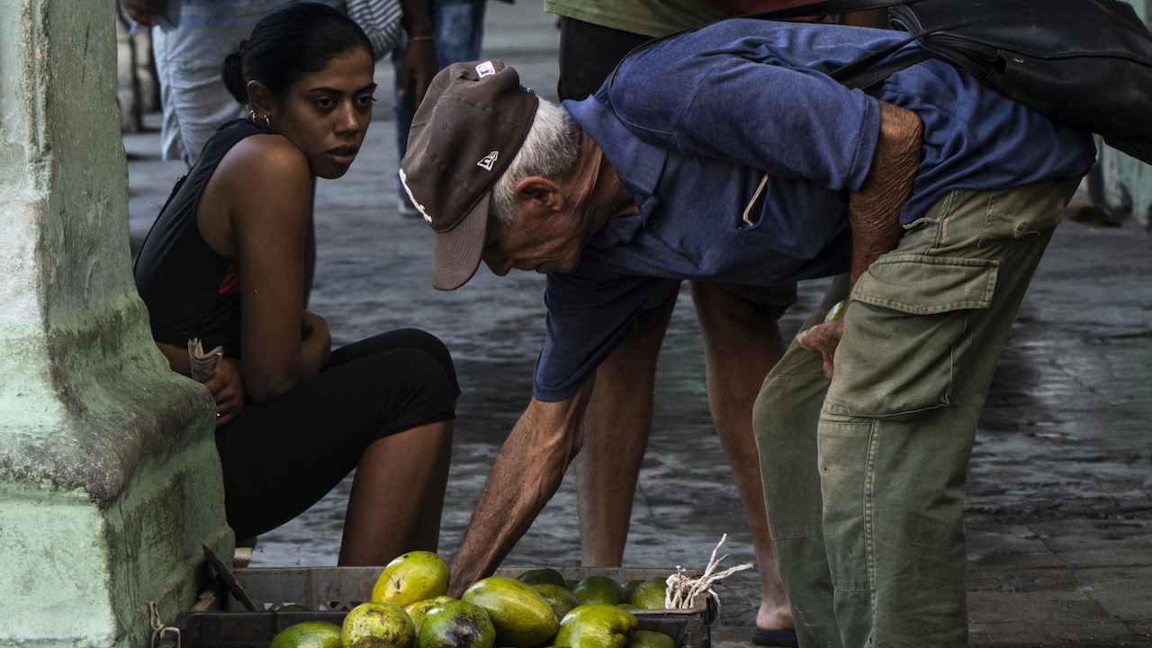 Una mujer vende aguacates en La Habana.