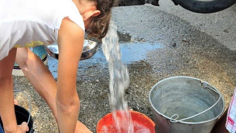 Vecinos de Sancti Spíritus reciben agua de una pipa.