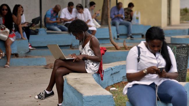 Cubanas conectadas a internet en una zona wifi.