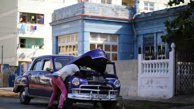 Un chofer cubano repara su auto.