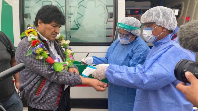 Personal médico le toma la temperatura al expresidente de Bolivia, Evo Morales, al arribar a la Provincia de Jujuy, en Argentina. 