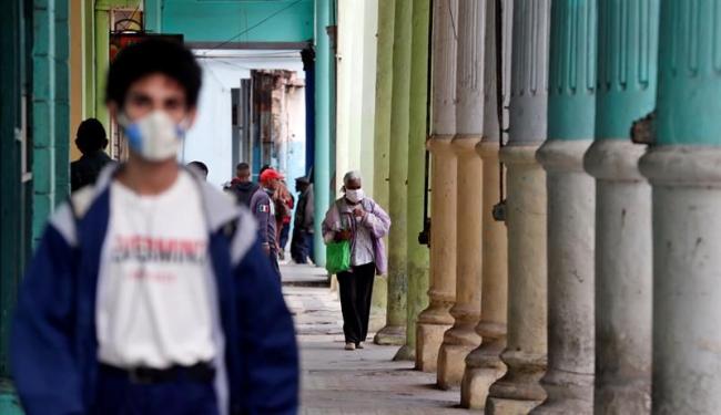 Cubanos caminan por portales de La Habana.