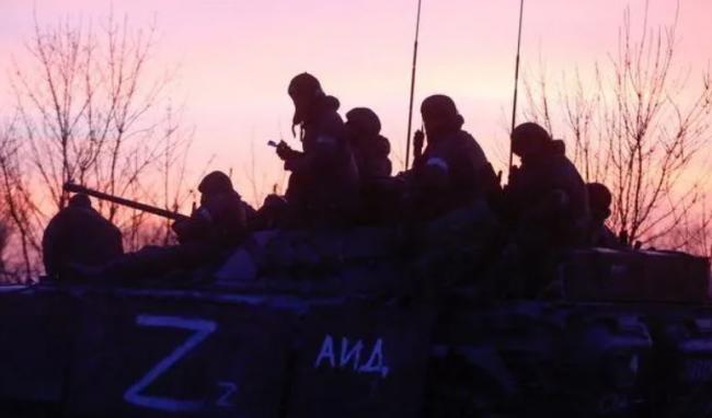 Soldados rusos, sobre un blindado, mientras atardece en una carretera cercada a Mariupol, el lunes. 