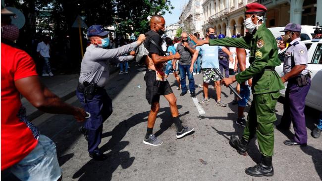 Agentes policiales detienen a cubanos durante las protestas.