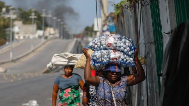 Vendedoras callejeras haitianas huyendo de un enfrentamiento entre pandillas en Puerto Príncipe.