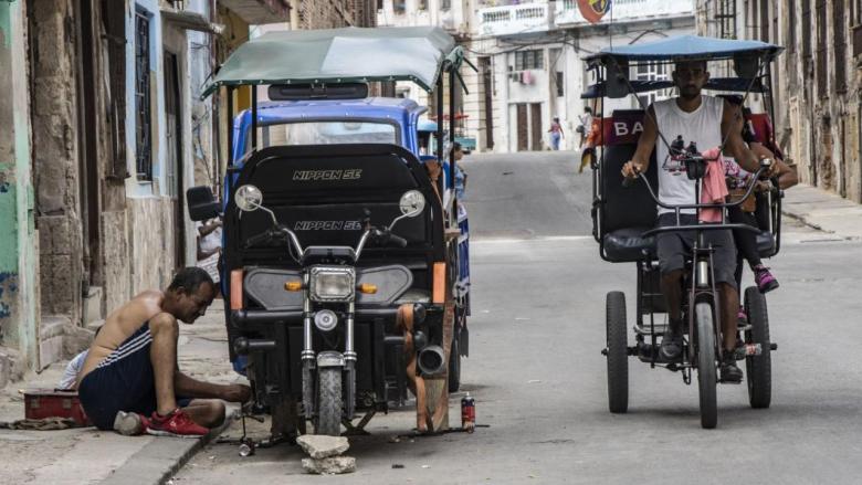 Un hombre trabaja en una moto adaptada en La Habana.
