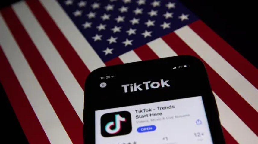 Aplicación de TikTok en un teléfono sobre una bandera de EEUU.